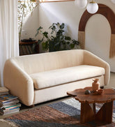 A cream-colored fabric loveseat sofa in a modern